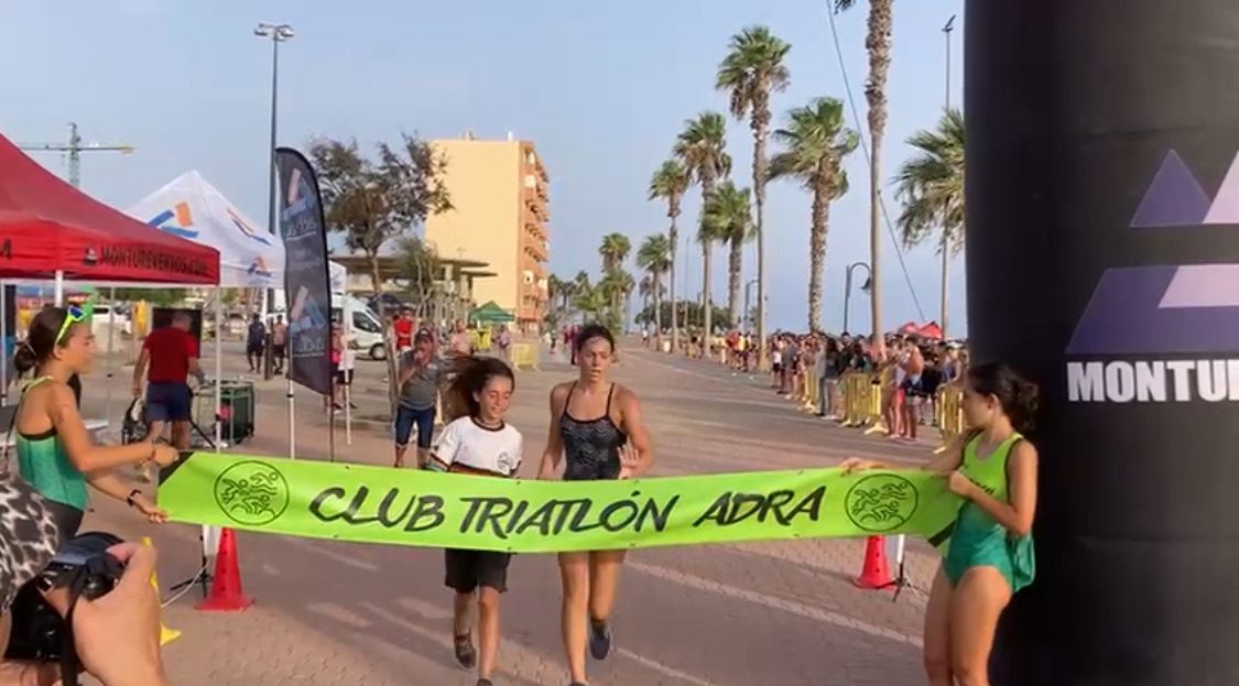 Crossing the finish line of an aquathlon on a seafront promenade
