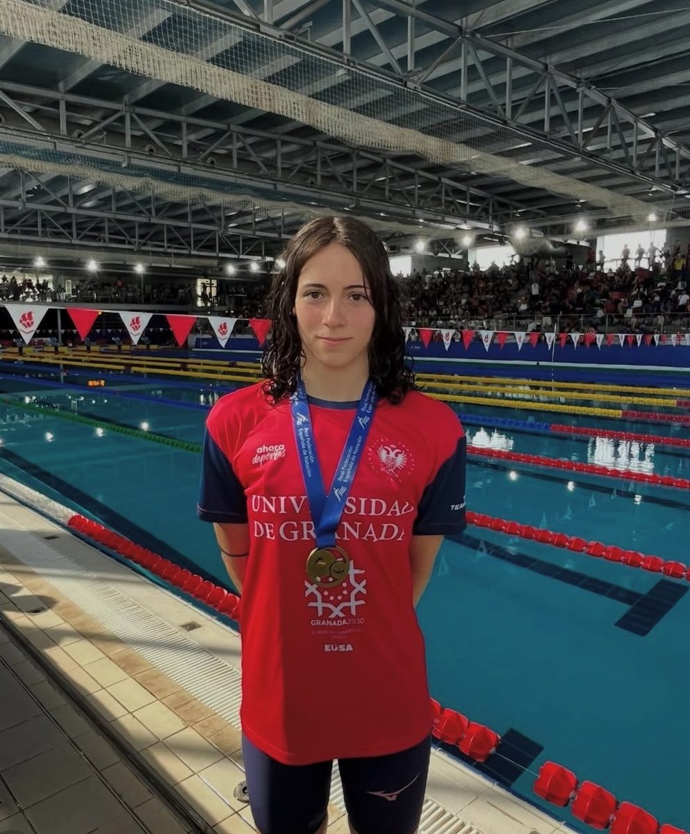 Zoë with a medal beside a 50-metre pool