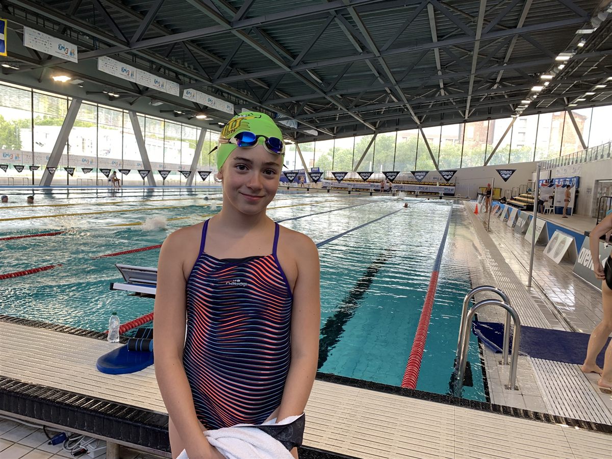Zoë aged 11 in a green cap beside an outdoor 50-metre pool