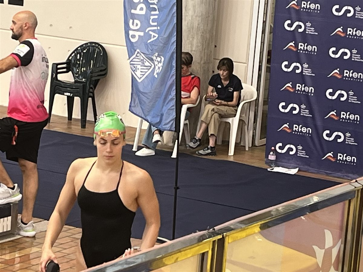 Zoë walking out to the pool deck in a green cap at the Open Trials