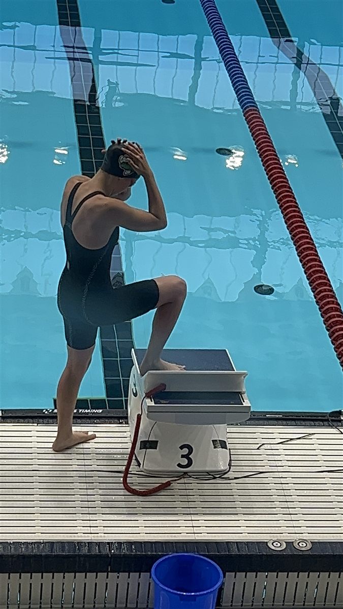 Zoë behind the lane 3 starting block of a 50-metre pool