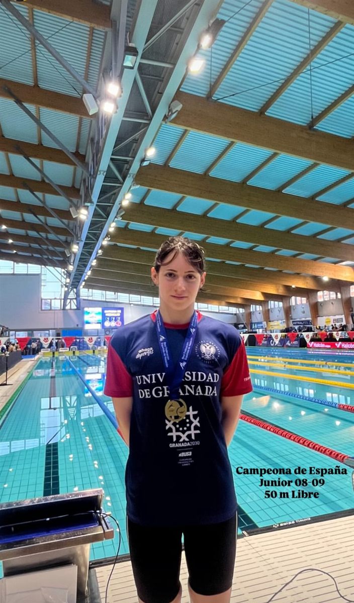 Zoë with the gold medal in front of the pool, captioned Spanish Junior Champion 08-09, 50 m freestyle
